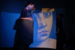 Dance performance with projected images on sheets.